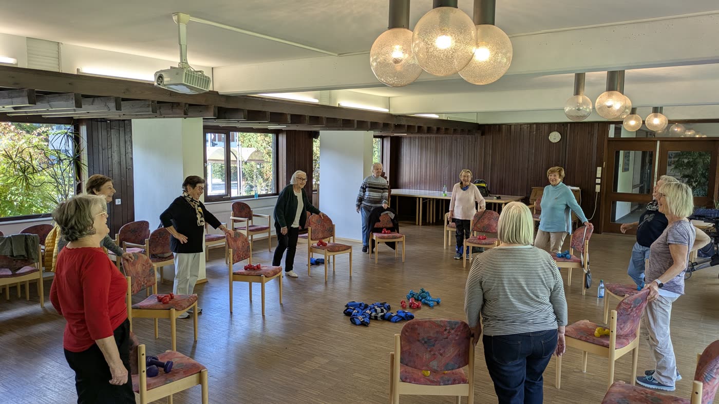 Training im Stehen mit Abstand zwischen den Stühlen