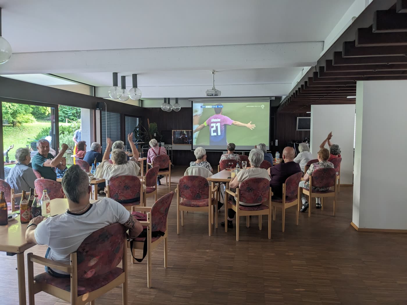 Public Viewing eines Fußballspiels auf der Großleinwand im Saal