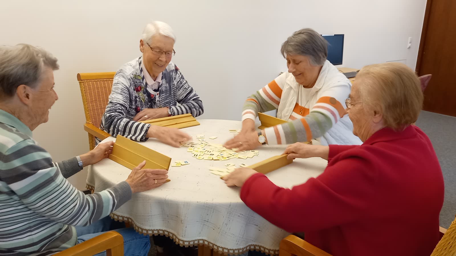 Vier Bewohnerinnen beim Spielenachmittag am runden Tisch